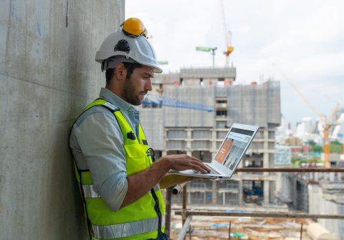 architect engineer designing a structure holding tablet, walkie talkie, drawing