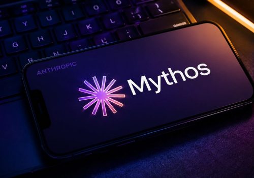 Smartphone displaying the word Mythos on a dark keyboard with purple and blue cyber themed lighting.